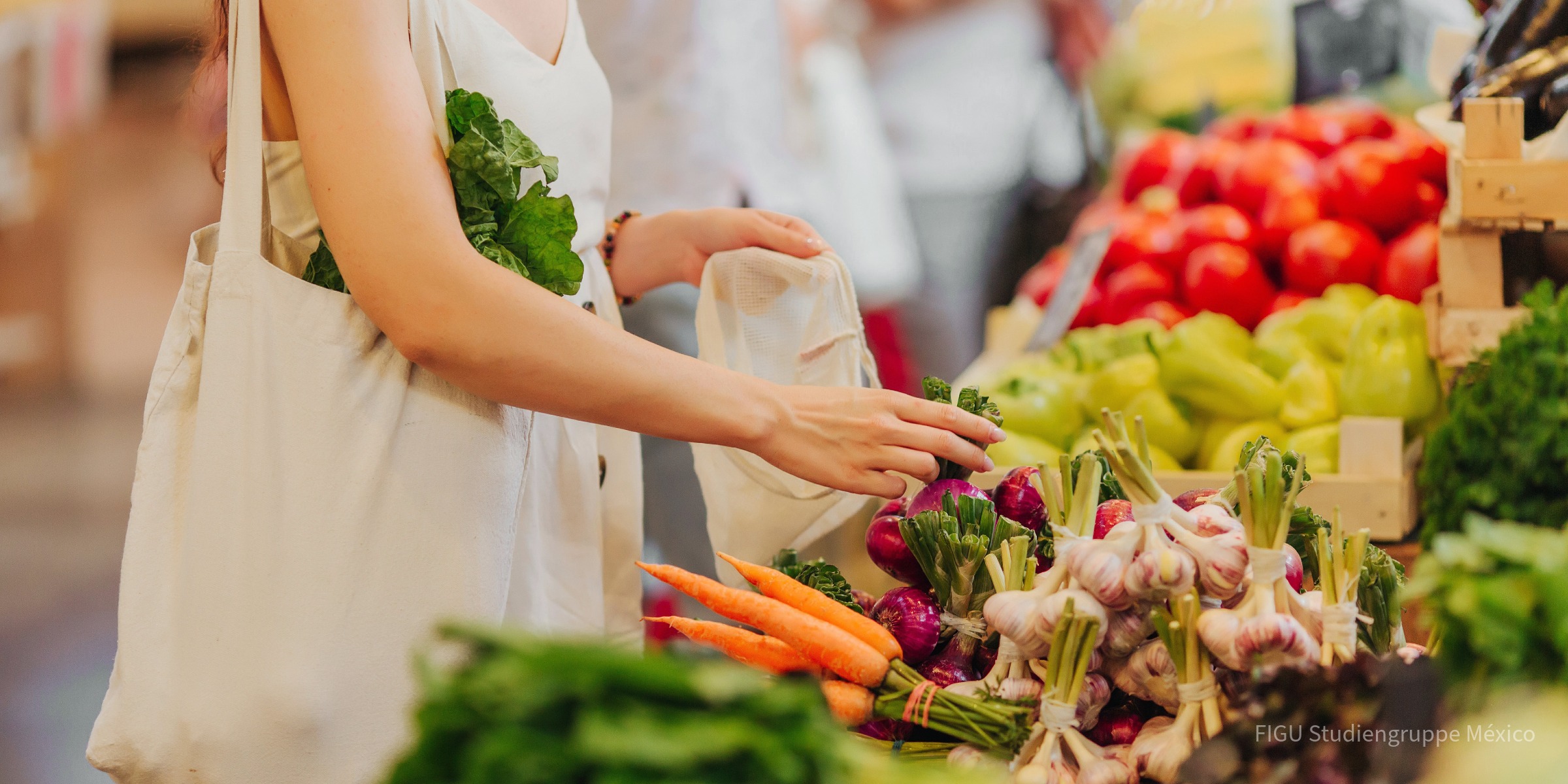 Manos colocando frutas y verduras en una bolsa de algodón en un mercado.