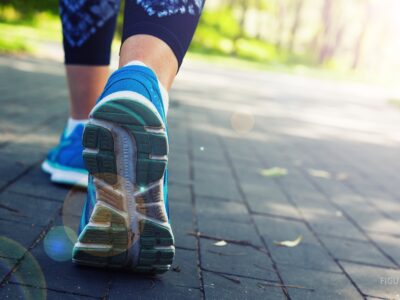 Piernas de una persona que corre por un camino de parque.