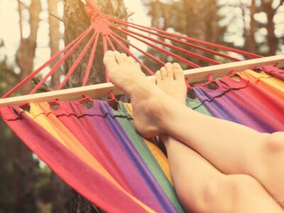 Persona descansando en una hamaca al aire libre.