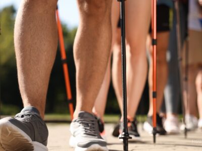 Personas practicando marcha nórdica con bastones al aire libre.